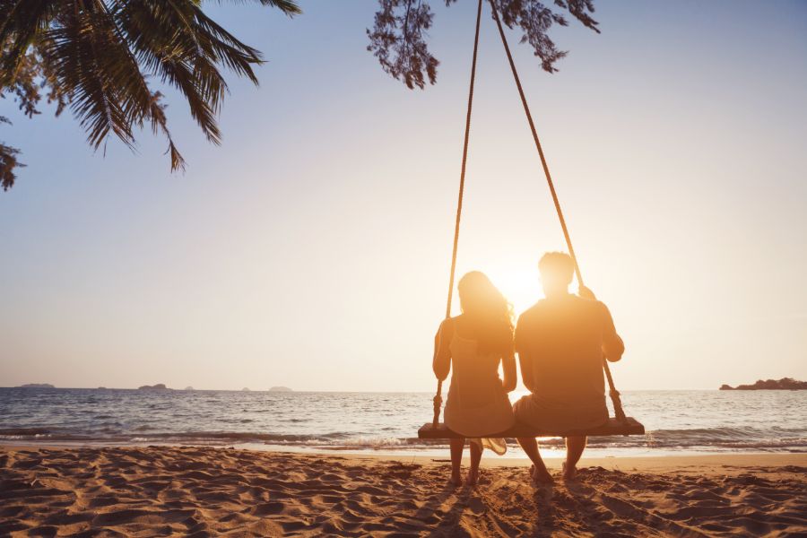 Honeymoon strand zonsondergang huwelijksreis van jonge man en vrouw