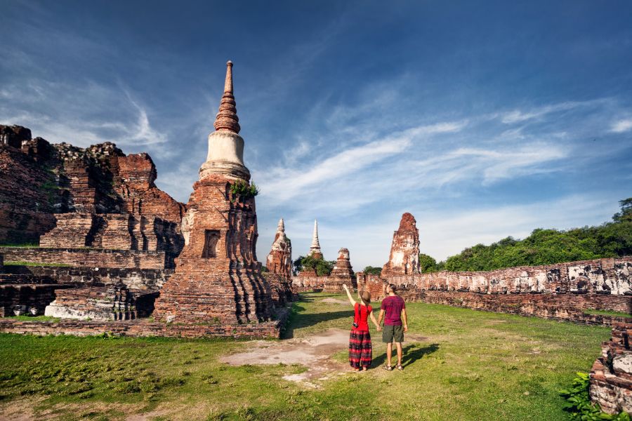 Thailand Ayutthaya Wat Mahathat boedhistische tempel Young couple with photocamera looking at ancient ruined tempel