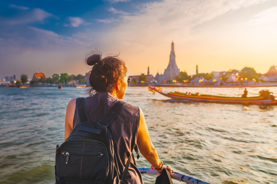 Thailand Bangkok Chao Phraya rivier uitzicht Wat Arun bij zonsondergang reiziger vrouw op boot