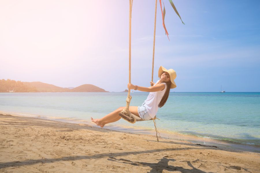 Thailand Koh Mak island vrolijke vrouw toerist met hoed schommelt op het strand