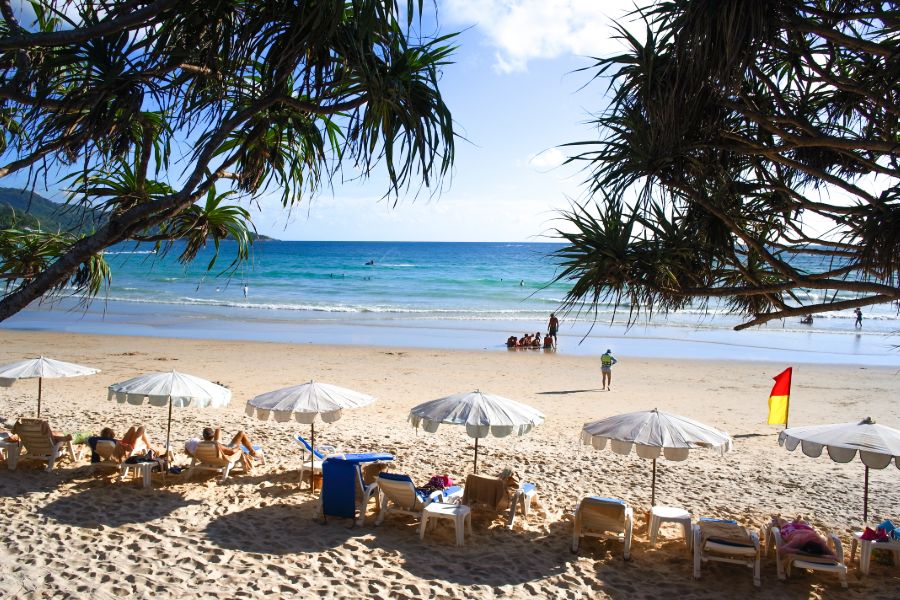 Thailand Phuket Kata Beach eiland strand zee palmbomen ligbedden parasols toeristen