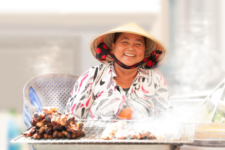 shutterstock 242994574 portrait a woman roasting kebabs vietnam vietnamese food smile happy market traditional asia asian business pork re